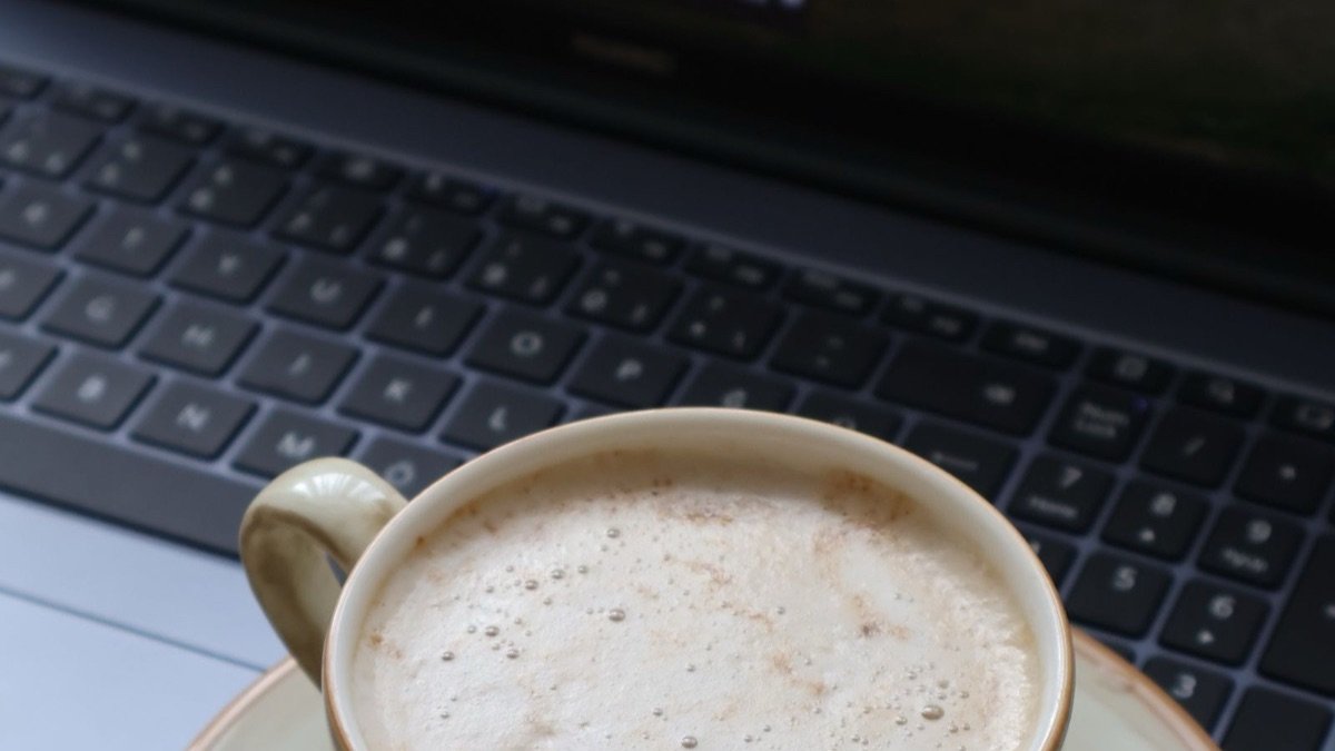 Xícara de café ao lado de um laptop