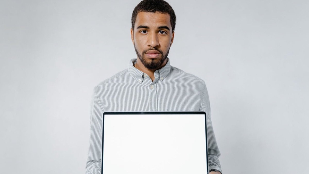 Pessoa segurando um laptop com a tela em branco